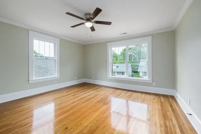 Bright room with new white double-hung windows looking onto green trees
