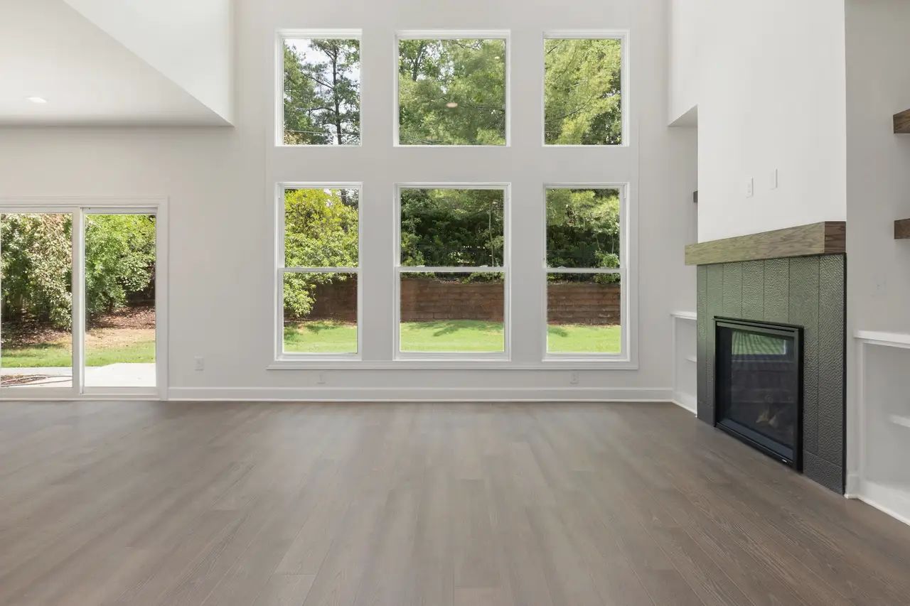 Living room with wide windows and a sliding door to the trees